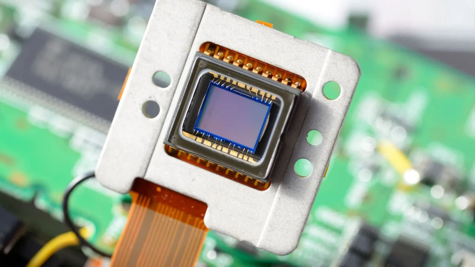 Capteur d'image nu monté sur son support métallique, nappe de connexion et carte électronique en arrière-plan.